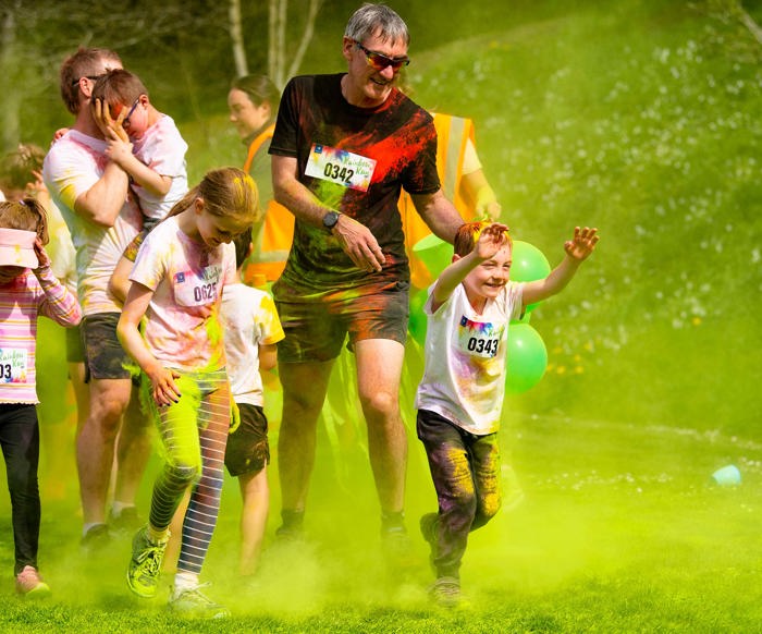 Children and adults running at the Rainbow Run.